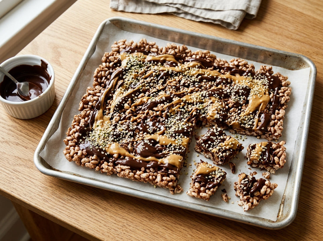 Protein packed rice cake bark with chocolate, peanut butter and hemp hearts on a parchment lined baking tray