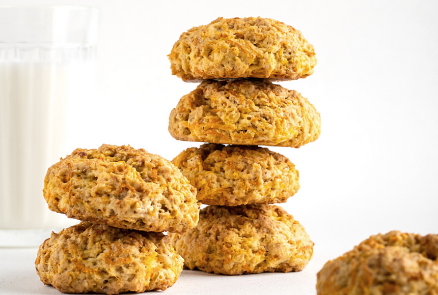 banana carrot flax cookies stacked on top of each other with a tall glass of refreshing milk 