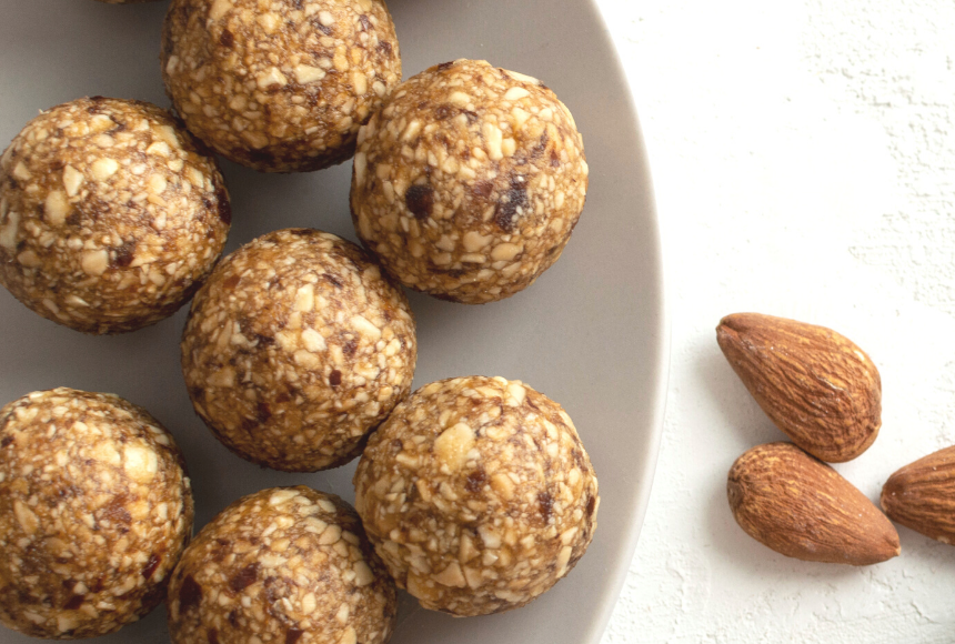 cookie dough chia bites displayed on a small plate with a few almonds on the side