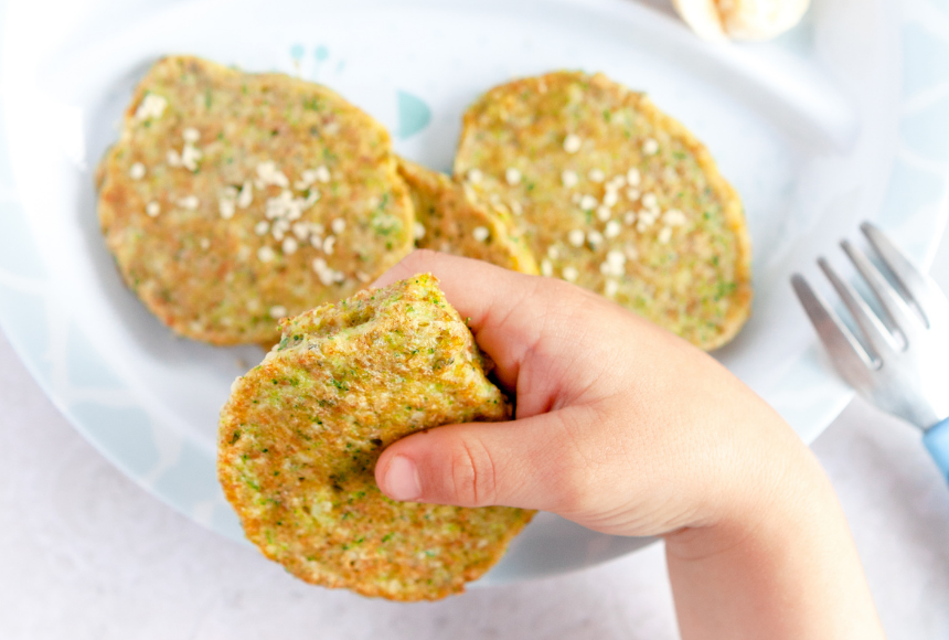 veggie fritters cooked lightly brown displayed on a small plate with a bowl of dip 