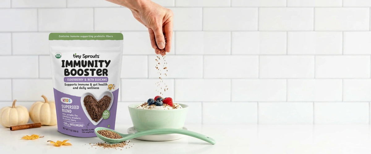 Tiny Sprouts Immunity Booster bag beside a spoon of seeds and a yogurt bowl